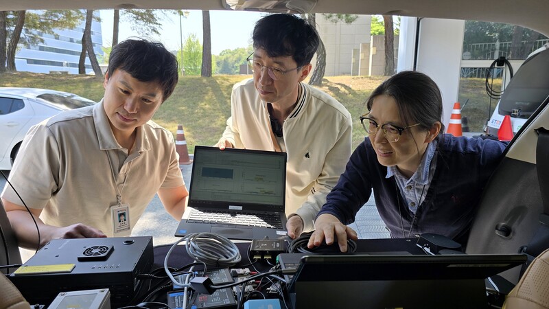 ETRI 연구진이 이기종 V2X 협력주행 통신기술에 관해 논의하는 모습