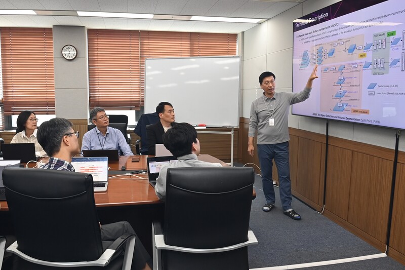 ETRI 연구진이 MPEG 국제표준화 회의에서 성과를 낸 ‘기계를 위한 비디오 특징 압축 기술(FCVCM)’의 기술 구조와 알고리듬에 대해 논의하는 모습